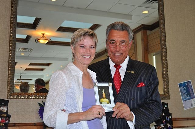 Christy Perry, of Destination Florida, receives an award from St. Armands Circle Association President Andrew Vac.