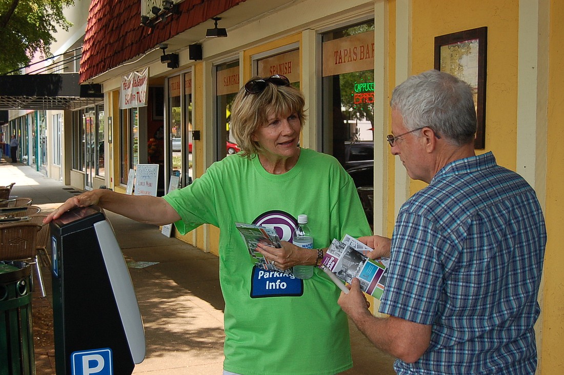 Mayor Suzanne Atwell helps a driver use a Main Street parking meter.