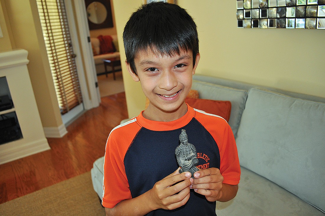 Willis Elementary student Alex Kumar shows off a replica of a statue he saw while visiting China.