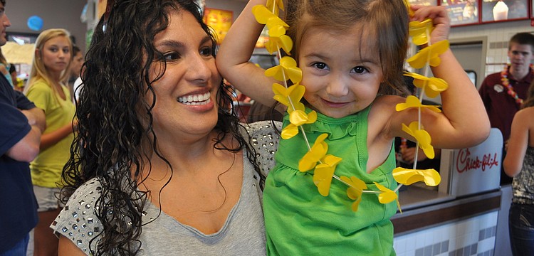 Gabriella Hunt, 2, was eager to put on her lei. She is pictured with her mom, Nina.