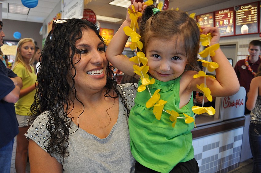 Gabriella Hunt, 2, was eager to put on her lei. She is pictured with her mom, Nina.
