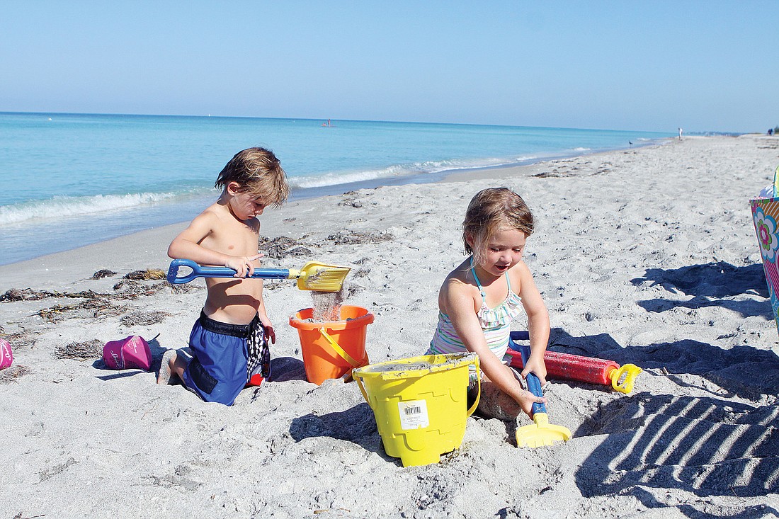 Charles Chappell, 5, and his sister, Claudia, 2 1/2, play in the sand Saturday on LongboatÃ¢â‚¬â„¢s beach during their vacation at the Sea Gate Club.