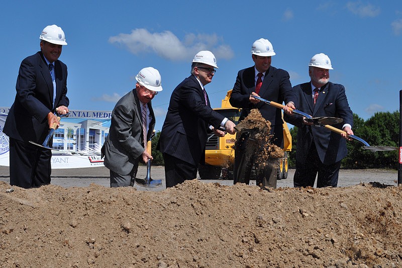 LECOM and other officials toss dirt as part of the ceremony.