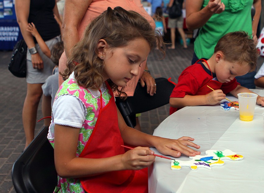 Ellie Russell, 8, paints a ceramic seahorse with all sorts of sea life figures during the World Ocean Day Family Festival Sunday, June 5 at Mote Aquarium.