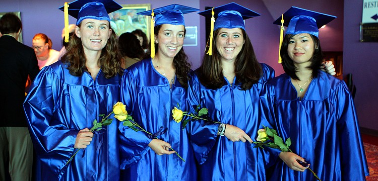 Colleen Wohlrab, Arianna Robbins, Mary Beth Bilder and Yvonne Hoang pose in their caps and gowns with their yellow flowers prior to their graduation from Pineview High School Sunday, June 5 at Van Wezel.