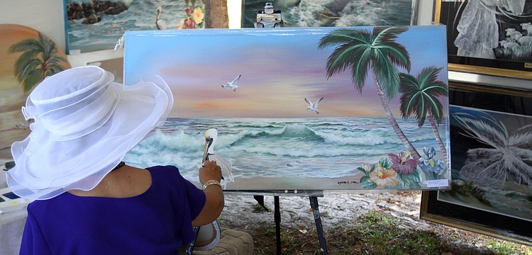 Kyung A. Park works on a painting while at the 10th Annual St. Armands Craft Festival Saturday June, 11 at St. Armands Circle.