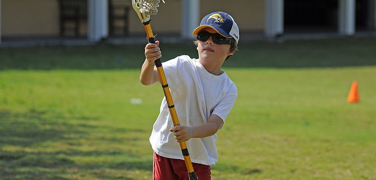 Seven-year-old Joshua Siegel practiced his stick skills while trying to score a goal.