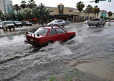 This red car has a difficult time making it through the flooded intersection downtown after an afternoon storm.