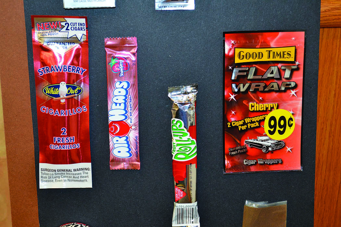 Sweet-flavored tobacco products, far left and far right, are packaged similarly to many candy products, center, with bright colors and sleek designs.