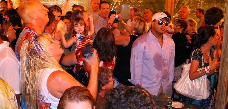 People huddled underneath the pavilion at Mar Vista in an attempt to get out of the rain, Saturday, July 2 during the Mar Vista Fireworks Spectacular.