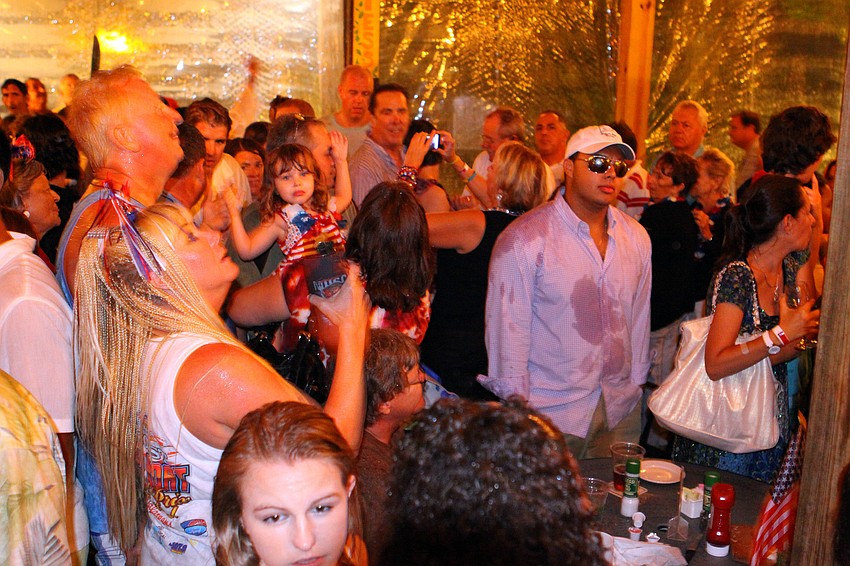 People huddled underneath the pavilion at Mar Vista in an attempt to get out of the rain, Saturday, July 2 during the Mar Vista Fireworks Spectacular.