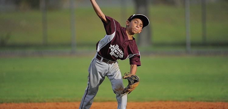 Infielder Devin Guzman makes a throw to home plate after retrieving a ground ball.