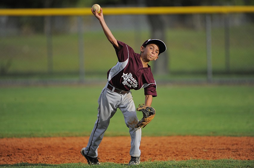 Infielder Devin Guzman makes a throw to home plate after retrieving a ground ball.