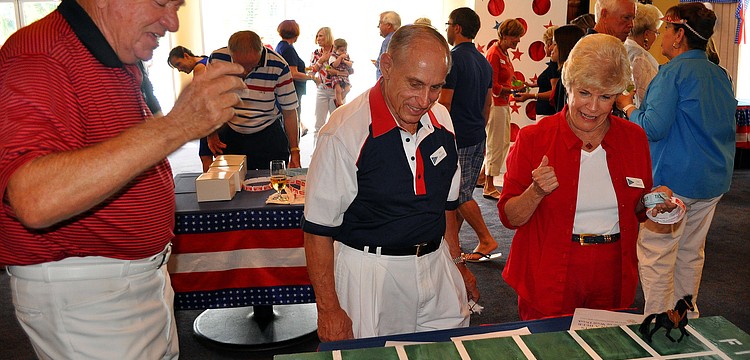 Marty Cooper plays a horse racing game with Bill and Judy Stanford Monday, July 4 at Bird Key Yacht Club.