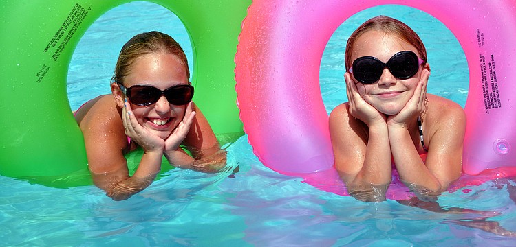 Isabella Zeppi, 9, and Kate Folkens, 9, have fun playing in green and pink innertubes Monday, July 4 at Sarasota Yacht Club.