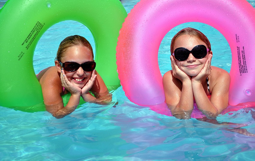 Isabella Zeppi, 9, and Kate Folkens, 9, have fun playing in green and pink innertubes Monday, July 4 at Sarasota Yacht Club.