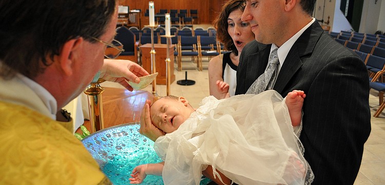Lori Wolcott gasps as Fr. Dan dumps the first bit of holy water onto her son, Colin Spencer, 6 mos., during his Baptism Saturday, June 18 at Our Lady of the Angels.