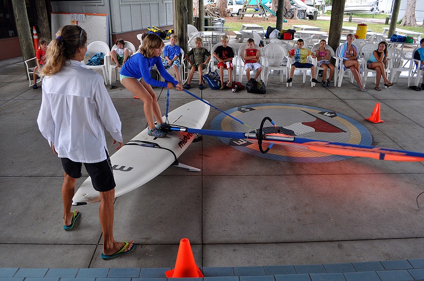 Laurel Kaiser steadies the simulator while Elizabeth Kamm, 9, starts to bring up her sail Friday, July 8 during the Island Style Water Sports Camp.
