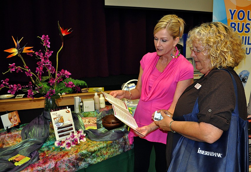 Donna Gaume shows Wendy Wilson all the services and products Mandala has to offer Wednesday, July 13 at Sarasota Prime Time.