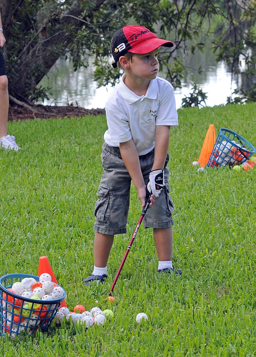 First-grader Jackson Payne practiced hitting pitch shots with a wiffle ball.