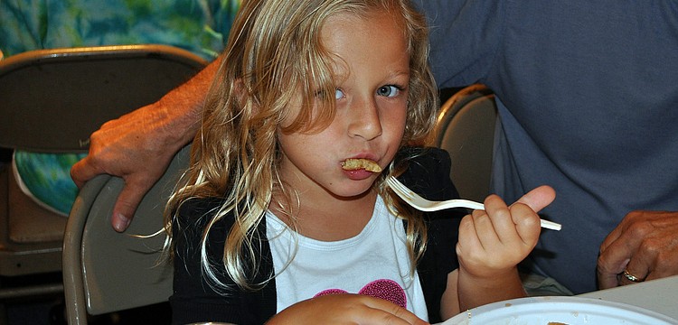 Lucy Zee, 5, takes a bite of one of her pancakes at the pancake breakfast put on by the Knights of Columbus Sunday, July 17 at St. Michael the Archangel Catholic Church.