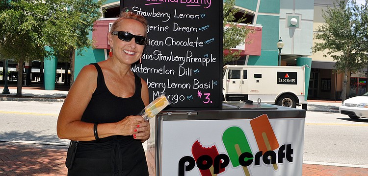 Donna Tortorice, co-owner of Pop Craft, poses out by her cart Monday, August 1 on the sidewalk across the street from Hollywood 20.