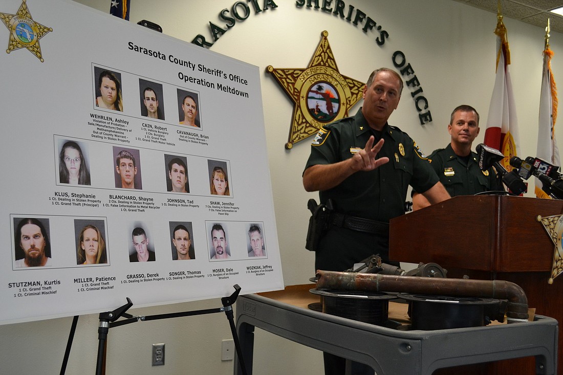 Sheriff Tom Knight, left, and Lt. John Jernigan display stolen metal and mug shots of the suspects in those thefts.