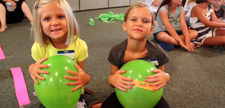 Ava, 4 Â½, and Chloe, 6 Â½, Tesinksy hold onto green ballons Monday, August 8 during vacation bible school at Siesta Key Chapel.