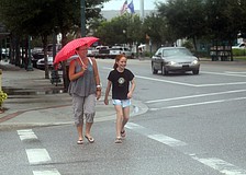 Lisa Knopp and her daughter, Grace, 11, walk to the bank in the rain after having lunch Wednesday, August 10 at Barnacle Bill's downtown.