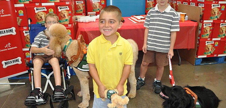 Grayson Tullio, center, has been waiting to get a service dog for two years. Grayson suffers from muscular dystrophy, and now, thanks to a partnership between Milk Bone and Sam's Club, he will be getting a service dog in 2012.