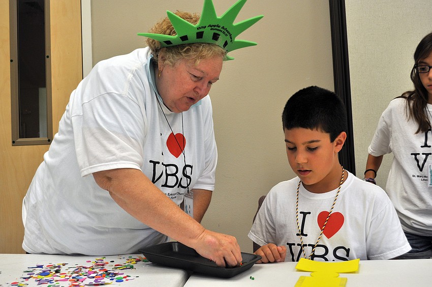 Posy Havens helps McNeal Elementary third-grader Gabe Hahn with his craft project.