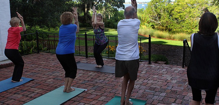 Nancy Zampella leads the class into the next yoga pose out on the Mansion's back porch at Selby Gardens. The class has the benefit of an hour long yoga class as well as taking in the breathtaking view of the gardens and the Bay.