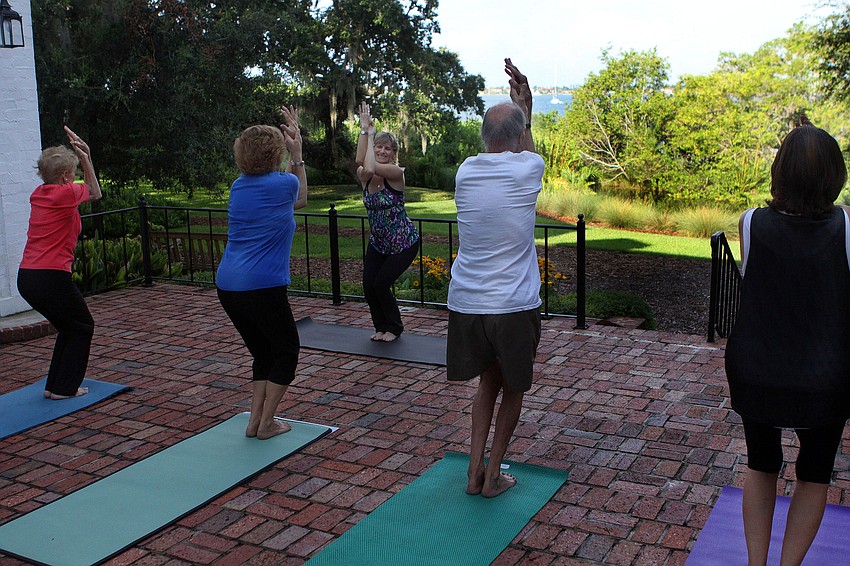 Nancy Zampella leads the class into the next yoga pose out on the Mansion's back porch at Selby Gardens. The class has the benefit of an hour long yoga class as well as taking in the breathtaking view of the gardens and the Bay.