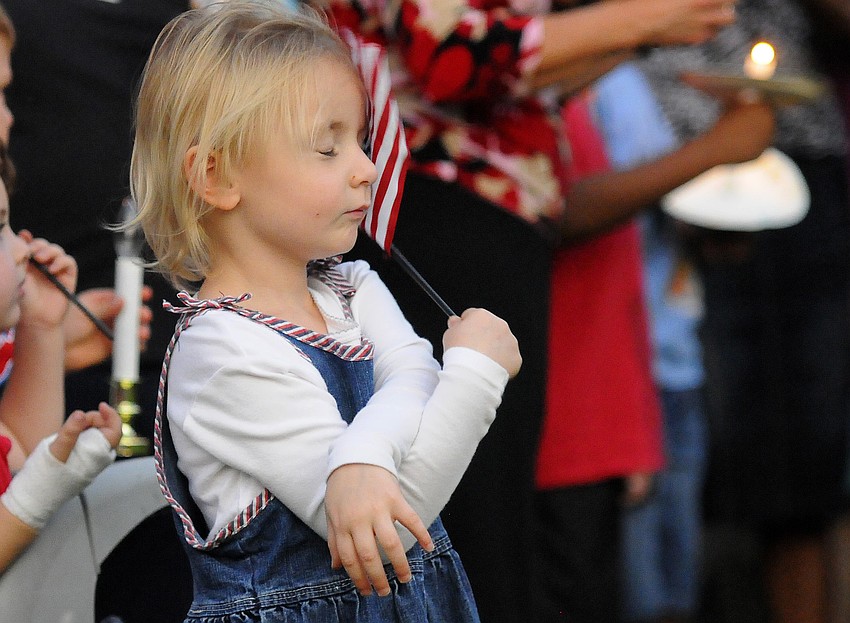 Two-year-old Sadie Evans prays during a candlelight vigil for U.S. Army Spc. 4 Patrick Lay II.