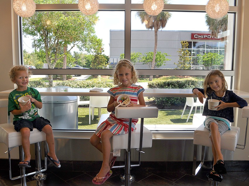 Will Ryan, 4, Molly Ryan, 6, and Channing Holder, 6, enjoy their yogurt creations Wednesday, Aug. 17 at Yogurtology on South Tamiami Trail.