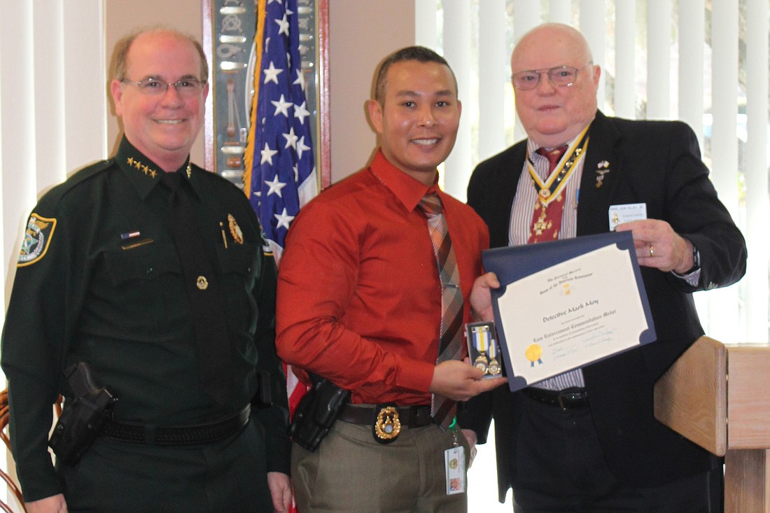 Detective Mark Moy (center) accepts his award. COURTESY PHOTOS