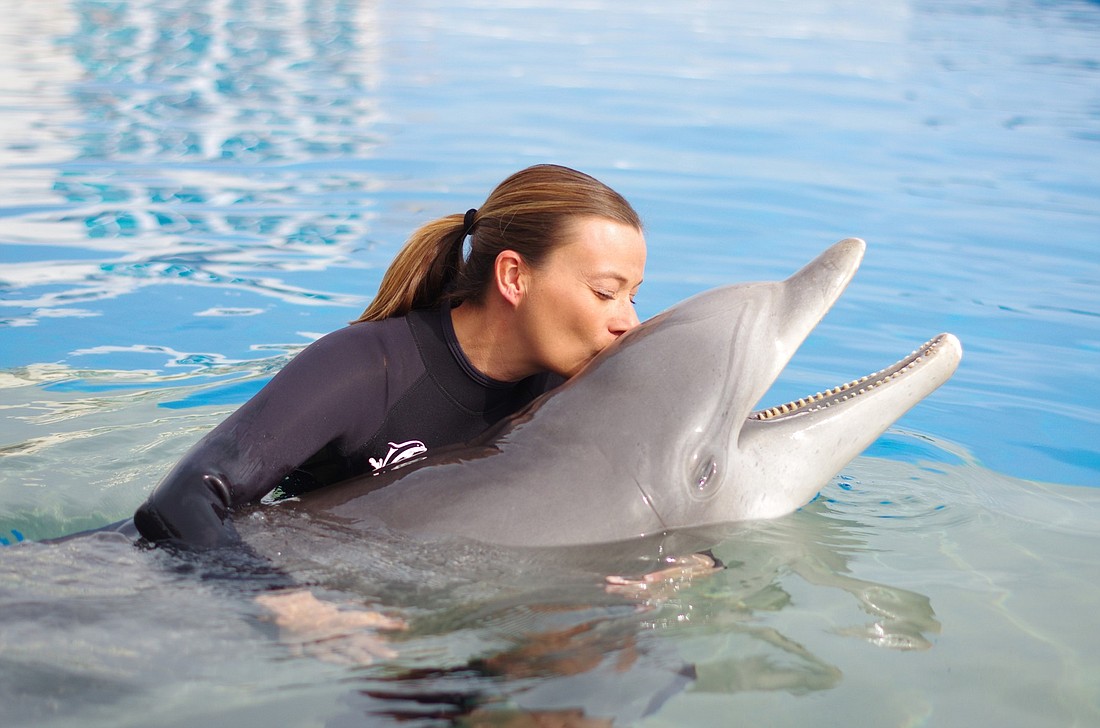 Animal Care staff member Jamie Stanley-Bahnsen shares an intimate moment with Nellie at Marineland Dolphin Adventure during the week of her 61st birthday. COURTESY PHOTOS