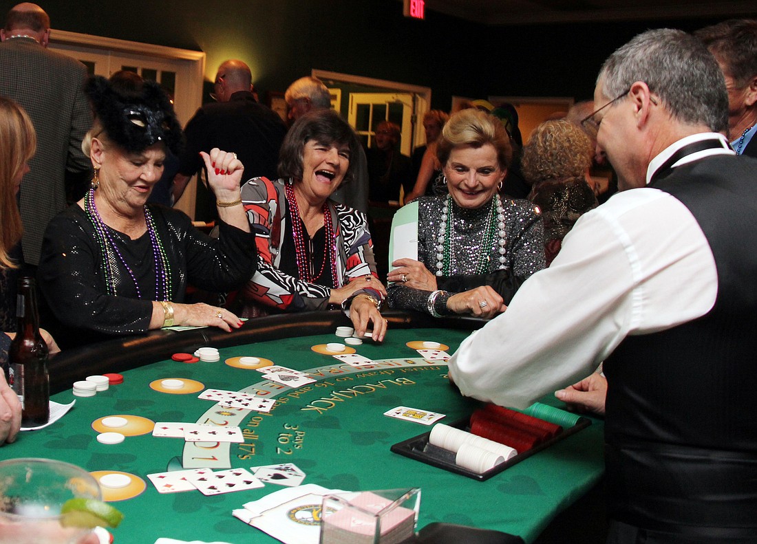 Attendees at the 11th-annual Mardi Gras and Casino Night exchange gaming bucks for chips at a variety of gaming tables. PHOTOS BY SHANNA FORTIER
