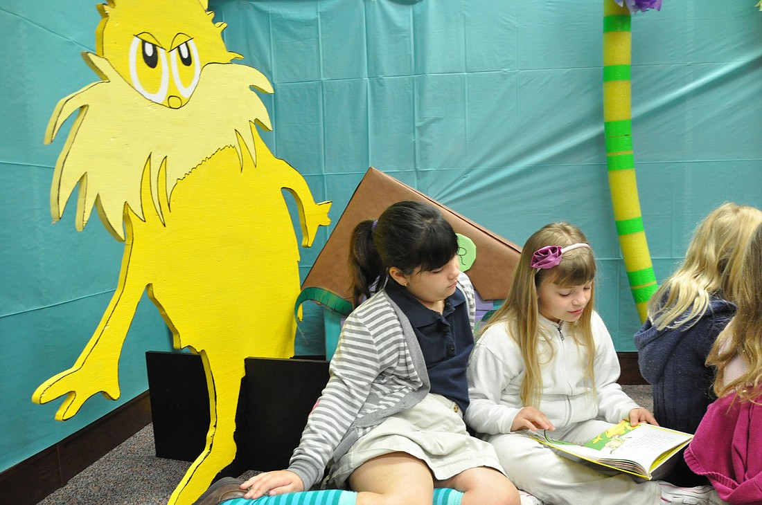 The Lorax peers over the shoulders of Chloe Stevenson and Haley Tarala, as they read in the Dr. Seuss Room at Old Kings Elementary School. PHOTOS BY SHANNA FORTIER