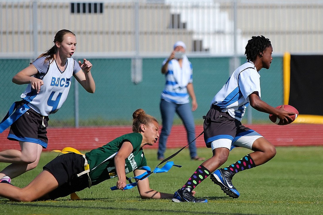 FPC's Leah Leach pulls the flag of Mainland's Zyreina Mincey after Mincey intercepted a pass. (Photo by Joey LoMonaco)