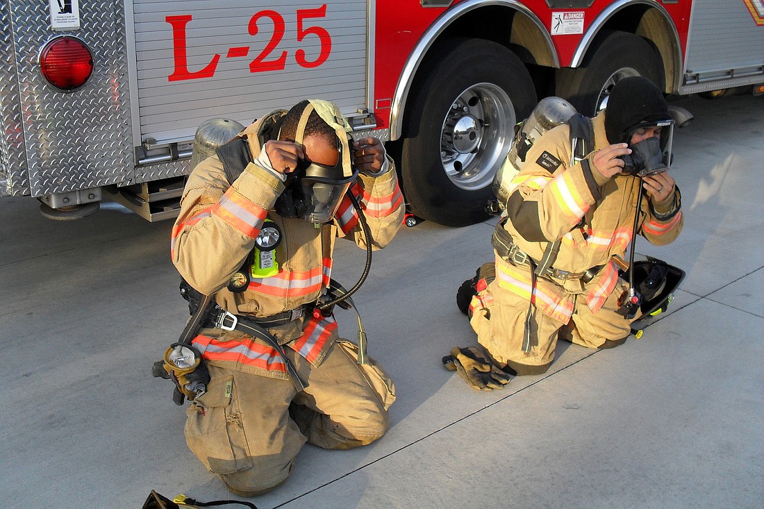 Palm Coast Firefighter Terrell Mitchell, left, and Firefighter Joey Paci III demonstrate use of self-contained breathing apparatuses. Courtesy photo.