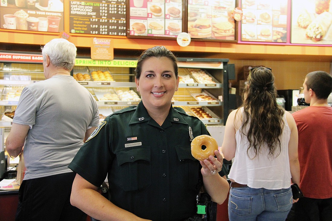 Deputy Paula Priester embraces the donut stereotype with a traditional glazed donut. PHOTOS BY SHANNA FORTIER