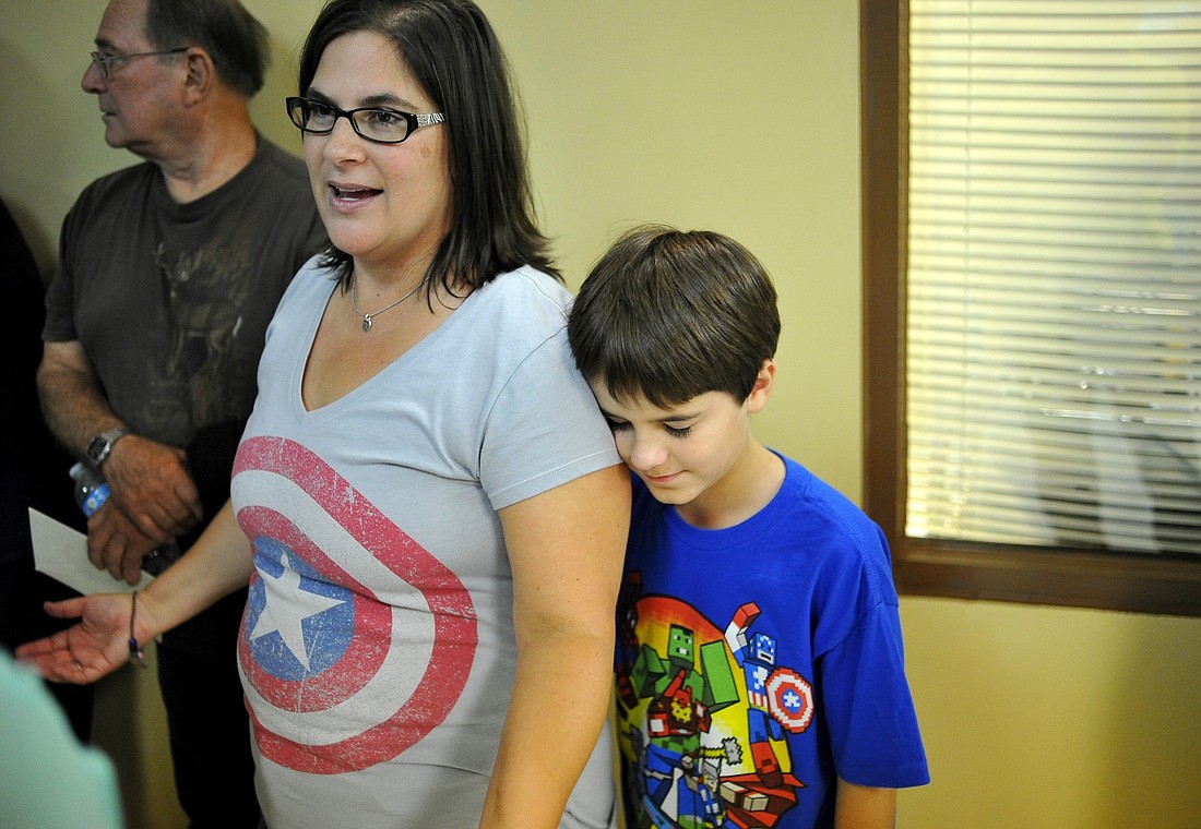 Jesse Doolin, 10, stands next to his mother Stacey as the family receives condolences following Rick Doolin's life celebration. (Joey LoMonaco)