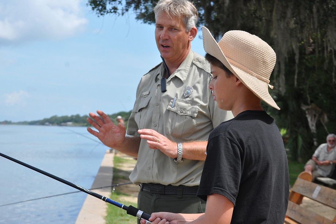 Park Ranger Joe Woodbury tells Ben Sturbelle about how to land a fish. (Photo by Jonathan Simmons.)