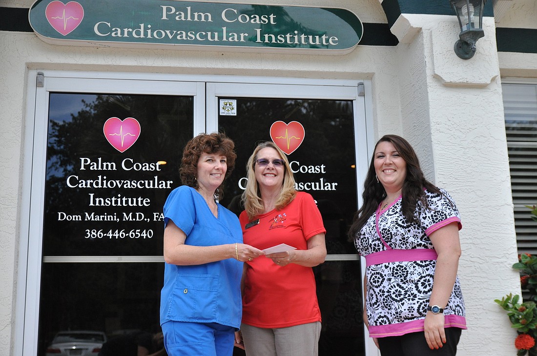 Laura Butts and Sophia Costa present a donation on behalf of Dr. Don Marini to Paula Wilburn and the Fun Coast Down Syndrome Association.
