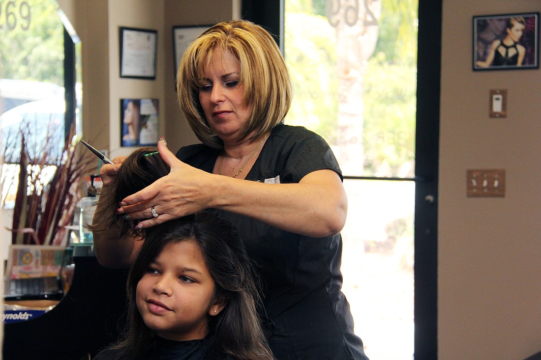 Jaynisi Guzman, 12, looks into the mirror envisioning her new hair style by Olga Soltero.