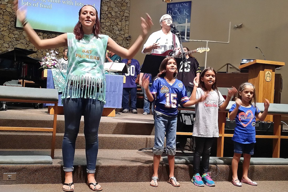 Jordan Lowe leads Victoria and Madeline Mannino and Nikki Lonergan as they sing "Big House" during the contemporary service of Palm Coast United Methodist Church's third-annual Football Sunday.