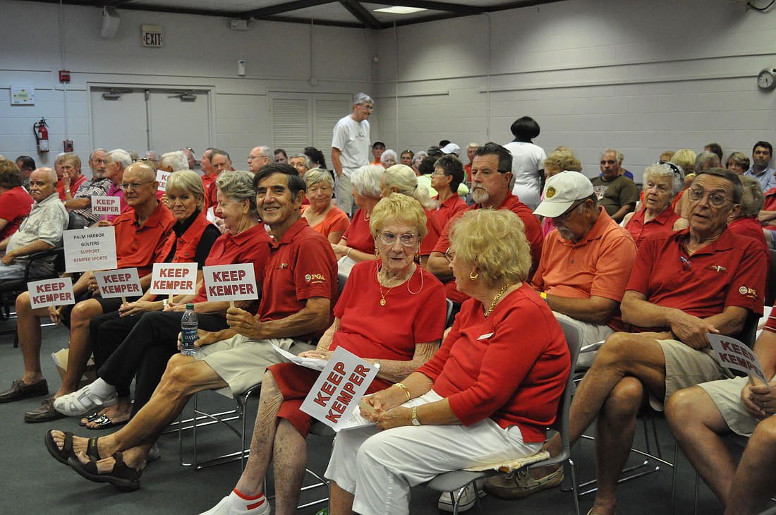 A crowd of people wearing red shirts and carrying "Keep Kemper" signs turned out to support Kemper Sports' bid to continue managing the Palm Harbor Golf Club. (Photo by Jonathan Simmons.)