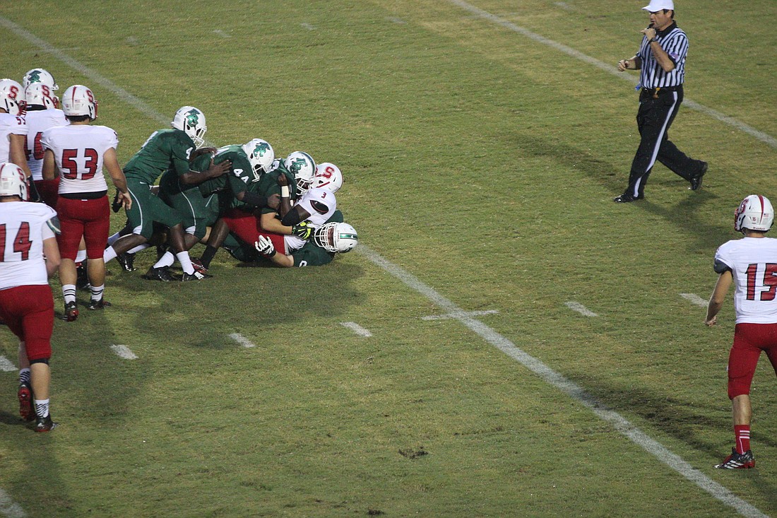 A group of FPC defenders stop a Seabreeze running back behind the line.