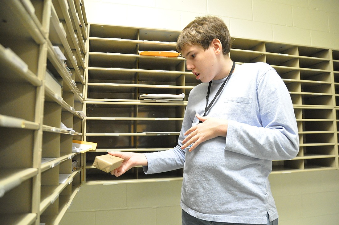 Elijah Moore sorts and delivers mail at Flagler Palm Coast High School as part of the community based instruction program. PHOTOS BY SHANNA FORTIER